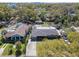 An aerial view shows a single-story home with a flat roof in a neighborhood with mature trees and green spaces at 200 W Louisiana Ave, Tampa, FL 33603