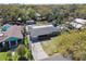 Aerial view of a single-story home nestled amongst mature trees, featuring a spacious yard and detached garage at 200 W Louisiana Ave, Tampa, FL 33603