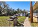 View of a backyard with lawn, grill, storage building, and a small concrete walkway in daylight at 200 W Louisiana Ave, Tampa, FL 33603