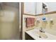 Small bathroom with shower, sink and toilet. The tiled area needs some TLC at 200 W Louisiana Ave, Tampa, FL 33603