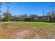 Expansive front yard leading to a single-story home with a charming screened-in front porch at 200 W Louisiana Ave, Tampa, FL 33603