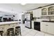 Traditional kitchen with breakfast bar open to living area, featuring stainless steel refrigerator and tile flooring at 200 W Louisiana Ave, Tampa, FL 33603