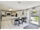 Bright kitchen featuring white cabinets, breakfast bar, and access to the backyard at 200 W Louisiana Ave, Tampa, FL 33603