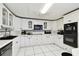 Traditional kitchen featuring white cabinets, black appliances, and tile flooring at 200 W Louisiana Ave, Tampa, FL 33603