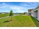Expansive backyard featuring lush green grass, a serene pond, and views of the surrounding community at 10714 Torchwood Sea Way, San Antonio, FL 33576