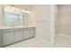 Bright bathroom featuring double sinks, modern lighting, and a spacious walk-in closet at 10714 Torchwood Sea Way, San Antonio, FL 33576