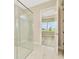 Bright bathroom featuring a glass-enclosed shower and a view to the backyard at 10714 Torchwood Sea Way, San Antonio, FL 33576