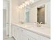 This bright ensuite bathroom features double sinks, quartz countertop, tile flooring and vanity lights at 10714 Torchwood Sea Way, San Antonio, FL 33576