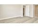 An empty bedroom with luxury vinyl flooring and a view of the yard at 10714 Torchwood Sea Way, San Antonio, FL 33576