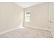 This bedroom features neutral walls, carpet and trim plus a bright window for natural light at 10714 Torchwood Sea Way, San Antonio, FL 33576