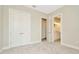 This bedroom features a view of the ensuite bathroom, a closet with double doors and carpet flooring at 10714 Torchwood Sea Way, San Antonio, FL 33576