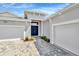 Stunning front entryway boasting double doors, meticulous landscaping, and stylish paver driveway leading to garages at 10714 Torchwood Sea Way, San Antonio, FL 33576