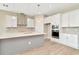 Modern kitchen with gray island, stainless steel appliances, and white cabinets at 10714 Torchwood Sea Way, San Antonio, FL 33576
