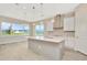 Modern kitchen with gray island, stainless steel appliances, and white cabinets at 10714 Torchwood Sea Way, San Antonio, FL 33576