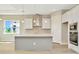 Modern kitchen with gray island, stainless steel appliances, and white cabinets at 10714 Torchwood Sea Way, San Antonio, FL 33576