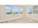 Bright living room with luxury vinyl plank flooring and large windows with backyard views at 10714 Torchwood Sea Way, San Antonio, FL 33576