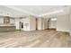 Bright, airy living room features wood-look tile flooring with kitchen and entryway nearby at 10714 Torchwood Sea Way, San Antonio, FL 33576