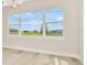 Bright living room with large picture window to backyard and luxury vinyl plank flooring at 10714 Torchwood Sea Way, San Antonio, FL 33576