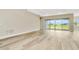 Bright, airy living room features wood-look tile flooring, neutral walls, and sliding glass doors to outdoor space at 10714 Torchwood Sea Way, San Antonio, FL 33576