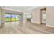 Bright, airy living room features wood-look tile flooring, neutral walls, and sliding glass doors to outdoor space at 10714 Torchwood Sea Way, San Antonio, FL 33576