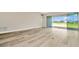 Bright, airy living room features wood-look tile flooring, neutral walls, and sliding glass doors to outdoor space at 10714 Torchwood Sea Way, San Antonio, FL 33576
