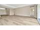 Bright, airy living room features wood-look tile flooring, neutral walls, and sliding glass doors to outdoor space at 10714 Torchwood Sea Way, San Antonio, FL 33576