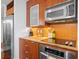 Modern kitchen with stainless steel appliances, wood cabinets and a tile backsplash at 111 N 12Th St # 1314, Tampa, FL 33602