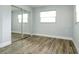 Bedroom with wood flooring, a closet with mirrored doors, and a window to fill it with natural light at 112 Rose St, Venice, FL 34293