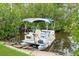 Pontoon boat docked on canal with lush, green surroundings at 112 Rose St, Venice, FL 34293