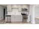 Updated kitchen with stainless appliances, white subway tile, gray cabinets, and stone counters at 112 Rose St, Venice, FL 34293