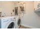 Functional laundry room with modern washer and dryer, and convenient electrical panel access at 112 Rose St, Venice, FL 34293