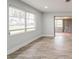 Bright, airy room with wood-look floors, and large window with wide doorway to a tiled sunroom at 112 Rose St, Venice, FL 34293