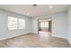 Bright, airy room with wood-look floors, and large window with wide doorway to a tiled sunroom at 112 Rose St, Venice, FL 34293