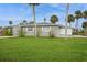Well-maintained property featuring a lush lawn and mature palm trees, creating a tropical oasis at 112 Rose St, Venice, FL 34293
