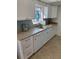 Bright white kitchen with granite counters, white appliances, and a stained glass window at 11251 80Th Ave # 210, Seminole, FL 33772