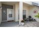 Inviting front porch with chairs, potted plants, decorative compass, and brick pavers at 11680 Shipwatch Dr # 1454, Largo, FL 33774