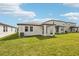 This backyard has green grass and a covered patio, great for outdoor gatherings at 129 Whiteland Bnd, Nokomis, FL 34275