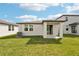 Backyard features lush green grass and a covered patio, ideal for outdoor relaxation at 129 Whiteland Bnd, Nokomis, FL 34275