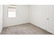Bedroom featuring an open white door, window and neutral carpeting at 129 Whiteland Bnd, Nokomis, FL 34275