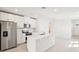 Kitchen features stainless steel appliances, white cabinets, and a center island with a sink at 129 Whiteland Bnd, Nokomis, FL 34275