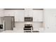 Close-up of the kitchen, featuring stainless steel appliances and white cabinetry at 129 Whiteland Bnd, Nokomis, FL 34275