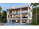 Modern waterfront home with multiple balconies, an expansive outdoor living area, and a refreshing pool at 1310 Boca Ciega Isle Dr, St Pete Beach, FL 33706