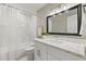 This bathroom features a shower/tub combo, with a large vanity with lots of counterspace and a white cabinet at 1464 S Evergreen Ave, Clearwater, FL 33756