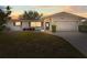 Charming single story home with a well-manicured lawn and mature trees against a lovely sunset at 1464 S Evergreen Ave, Clearwater, FL 33756