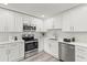 Updated kitchen boasting stainless steel appliances, sleek white cabinetry, and stylish subway tile backsplash at 1464 S Evergreen Ave, Clearwater, FL 33756