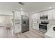 Updated kitchen with white cabinets, stainless appliances, and seamless flow into the adjacent living space at 1464 S Evergreen Ave, Clearwater, FL 33756