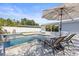 Backyard pool view with lounge seating, umbrella, and fence at 1464 S Evergreen Ave, Clearwater, FL 33756