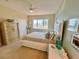 Comfortable bedroom boasts water views, a ceiling fan, and a neutral color scheme at 1616 Sand Key Estates Ct, Clearwater Beach, FL 33767