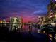 Night view of condo buildings and yachts reflecting lights in the water under a purple and red sky at 1616 Sand Key Estates Ct, Clearwater Beach, FL 33767