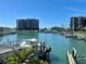 Waterfront view showcasing a marina, boats, and waterfront condominiums under a clear sky at 1616 Sand Key Estates Ct, Clearwater Beach, FL 33767